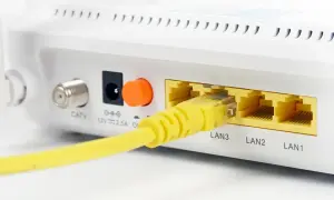 Żółty kabel sieciowy podłączony do portu LAN3 routera. Obok widoczne porty LAN2 i LAN1.