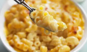 Une cuillère de mac and cheese crémeux et doré, prêt à être dégusté.