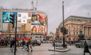 Tętniące życiem Piccadilly Circus z neonami, ludźmi i słynnymi billboardami.