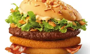 Burger McRoyal z bekonem, sałatą, cebulką i sosem.