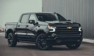 Svart Chevrolet Silverado High Country, en av många imponerande Chevrolet modeller, parkerad framför en modern byggnad.