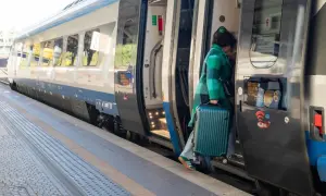 Kobieta z walizką wsiada do pociągu Pendolino. Szybkość i komfort podróży to jego znaki rozpoznawcze.