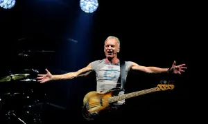 Sting śpiewa na koncercie, trzymając gitarę basową. Jego ramiona są rozłożone, jakby chciał objąć cały świat. Tekst "sting shape of my heart" idealnie pasuje do tej sceny.