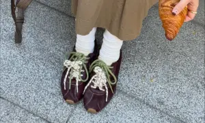 Modne sneakersy 2026 w bordowym kolorze, z zielonymi i białymi sznurówkami, idealne na spacer z croissantem.