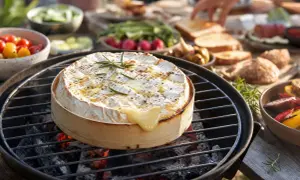 Un camembert au barbecue, fondant et parfumé, est le cœur d'un repas en plein air. Des légumes et du pain complètent ce délice.