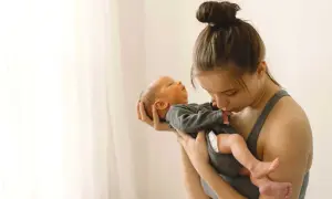 Madre abraza a su bebé recién nacido. La ternura en sus miradas hace olvidar cuánto dura la cuarentena.
