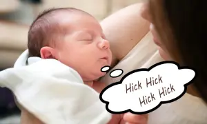 En sovande bebis med hicka, inlindad i en vit filt. En pratbubbla visar "Hick Hick Hick Hick".