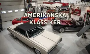En samling amerikanska klassiker, inklusive 70 tals bilar, i ett garage. En beige cabriolet står i förgrunden.