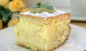 Puszyste ciasto przełożone kremem budyniowym, posypane cukrem pudrem i ozdobione ananasem. Pyszne ananasowiec ciasto!