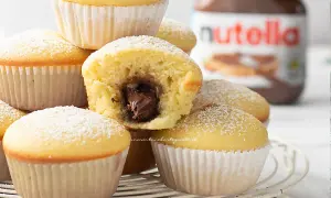 Muffin soffici con cuore di Nutella, perfetti per una ricetta muffin semplici e golosa. Spolverati di zucchero a velo.