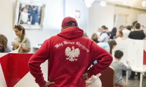 Polacy w UK. Mężczyzna w czerwonej bluzie z orłem i napisem "Bóg Honor Ojczyzna" stoi w tłumie.