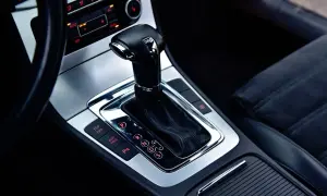 Błyszcząca dźwignia zmiany biegów skrzyni DSG w nowoczesnym samochodzie. Widoczne przyciski ESP, Auto Hold i P.