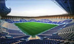 Puste trybuny stadionu Al Nassr czekają na kibiców. Zielona murawa lśni w słońcu, gotowa na emocjonujące mecze.