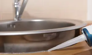 Aplikacja silikonu wokół zlewu. Zastanawiasz się, ile godzin schnie silikon? Czas schnięcia zależy od wielu czynników.