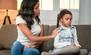 Una madre consuela a su hija, cuyos ojos reflejan la fragilidad de los niños cristal.