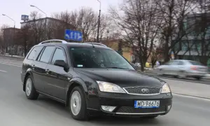 Czarny Ford Mondeo MK2 kombi jedzie ulicą.