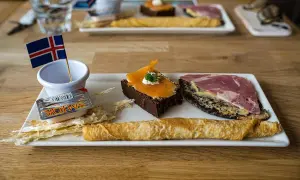 Na talerzu islandzkie przysmaki: ciemne ciasto z łososiem, chleb z wędliną, naleśnik i suszone ryby. Idealne jedzenie na Islandię!
