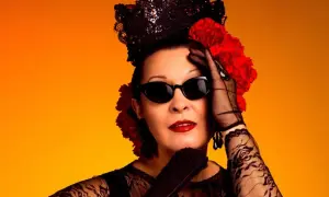 Jarcha, con su estilo inconfundible, evoca un martirio flamenco con encaje negro, gafas oscuras y flores rojas sobre fondo naranja.