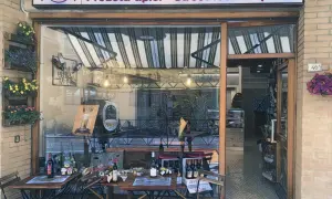 Delizie Marchigiane: prodotti tipici e street food di qualità ad Ancona. Tavolini all'esterno invitano a gustare le specialità locali.
