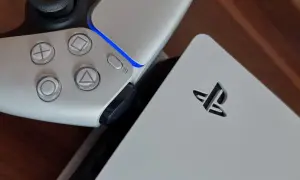 Zbliżenie na biały kontroler PlayStation 5 i konsolę z logo.