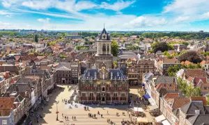 Luftaufnahme von Delft mit dem Rathaus im Zentrum. Entdecken Sie die charmanten Gassen und versteckten Plätze – echte Delft Geheimtipps.