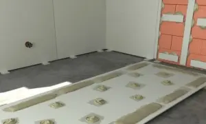 Płyta GK z masą klejącą gotowa do montażu. Pokazuje, czym przykleić płytę GK do ściany, stosując metodę "placków" i "wstęg".