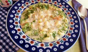 Pyszna zupa na wywarze z golonki z makaronem i koperkiem, podana w ozdobnym talerzu.