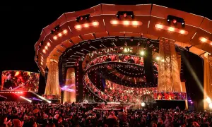Ogromna scena z ekranami LED i tłumem ludzi. To prawdopodobnie koncert sylwestrowy w Warszawie, pełen świateł i emocji.