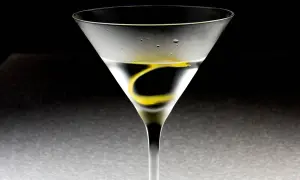 Ein Martini-Cocktail in einem Glas mit Zitronenzeste und Kondenswasser.