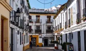 Callejuela cordobesa con casas blancas, balcones de hierro y faroles. Un cartel anuncia "Entrada Gratuita", ideal para saber qué ver en Córdoba gratis.