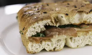 Un sandwich gourmand garni de jambon et de fromage, servi dans un pain italien moelleux et croustillant.