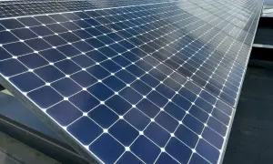 Panele fotowoltaiczne na dachu, które mogą zasilać piec elektryczny do podłogówki, odbijają niebo.