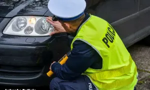 Policjant sprawdza reflektor, czy żarówki postojowe led są legalne. Lubuska Policja.