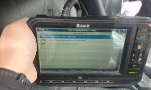 Escáner G-SCAN 2 muestra código C1201, fallo en sistema de control de motor de un Toyota.