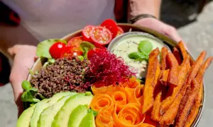 Ein farbenfroher Buddha Bowl mit Quinoa, Avocado, Karottenrosen, Süßkartoffel-Pommes und einem cremigen Dip. So schmeckt froindlichst Berlin!