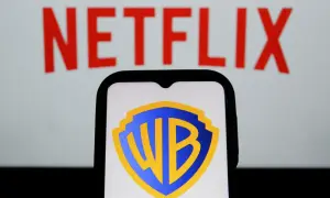 Logo Warner Bros. na ekranie telefonu, w tle napis Netflix. Analiza akcji WBD.