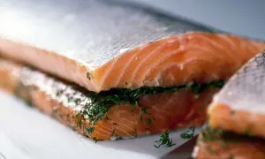 Två bitar lax, en ovanpå den andra, med dill emellan. Förbereds för lax i ugn.