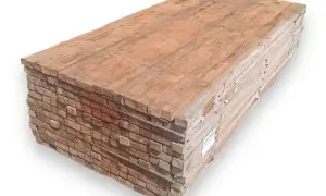 Pila de tablones de madera, mostrando la textura y el color rojizo característico de que es la madera tropical, lista para construcción.