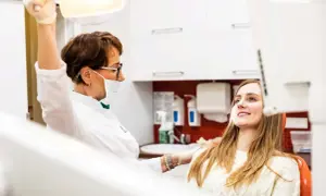 Dentystka przygotowuje się do chirurgicznego usuwania ósemki w ciąży. Pacjentka uśmiecha się, ufając profesjonalistce.
