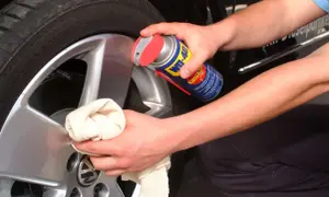 Hände reinigen Felgen mit WD-40 und Tuch. Ein einfacher felgenreiniger hausmittel-Trick für glänzende Alufelgen.