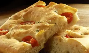 Focaccia moelleuse aux tomates et herbes, un délice qui rappelle la pizza.