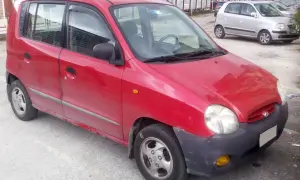 Röd Hyundai Atos parkerad utomhus. En annan silverfärgad bil syns i bakgrunden.