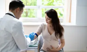 Lekarz pobiera krew od ciężarnej kobiety, badając podwyższone neutrofile w ciąży.