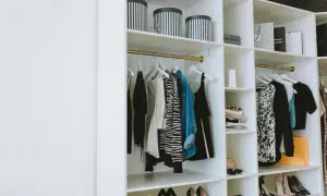 Estanterías armario con ropa colgada, cajas y zapatos organizados.