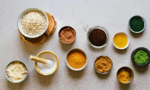Ingredienser för hemmagjord ansiktsskrubb: havregryn, kakaopulver, kaffesump, gurkmeja, matcha och olja.