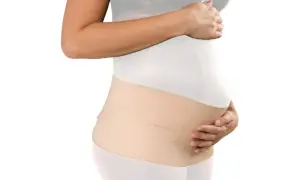Mujer embarazada con una faja postparto de color beige, que brinda soporte y comodidad.