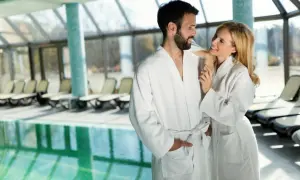 Para w szlafrokach przy basenie w spa.