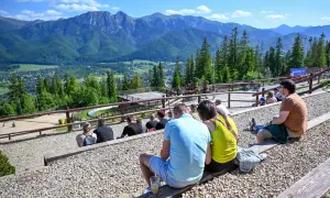 Widok na Tatry z widowni, gdzie ludzie odpoczywają, ciesząc się atrakcjami Poronina.