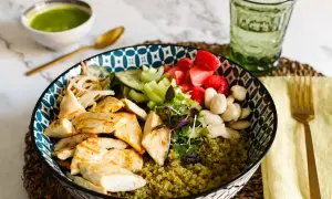 Una ciotola colorata con pollo grigliato, verdure fresche, fragole e mandorle su un letto di cous cous. Perfetta per le tue ricette con il cous cous.