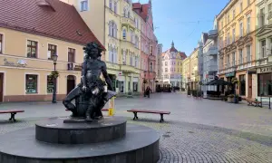 Pomnik w centrum miasta, kolorowe kamienice, ławki i brukowana ulica. Zielona Góra atrakcje turystyczne zachęcają do spacerów.